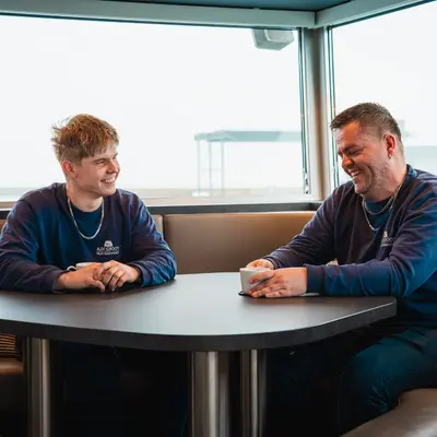Twee collega's van A. de Groot in gesprek aan boord van een binnenvaartschip